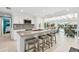 Modern kitchen with white cabinets, an island with bar stools, and views of the pool and outdoor dining area at 4011 99Th W St, Bradenton, FL 34210