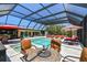 This screened-in pool boasts ample seating, a spa, a tv, and an outdoor kitchen for the ultimate outdoor retreat at 4011 99Th W St, Bradenton, FL 34210
