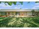 Back exterior of home with a well-maintained lawn and multiple doors at 4144 Hampton Dr # C, New Port Richey, FL 34652
