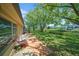 Backyard view with mature trees, lush green grass, a patio with chairs, and a peaceful canal at 4144 Hampton Dr # C, New Port Richey, FL 34652
