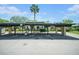 Exterior view showing covered parking, townhome facade, mature landscaping, and bright daytime sky at 4144 Hampton Dr # C, New Port Richey, FL 34652