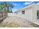 Backyard gravel area features a white brick home with a white fence and mature palm tree at 4500 22Nd N Ave, St Petersburg, FL 33713