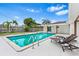 Backyard view of a clear swimming pool, with sun loungers and lush landscaping, under a partly cloudy sky at 4500 22Nd N Ave, St Petersburg, FL 33713