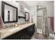 Elegant bathroom featuring double sinks, granite countertops, decorative mirrors, and a tiled shower at 4519 S Grady Ave, Tampa, FL 33611