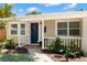 Charming home featuring a vibrant blue door and covered front porch, with lush landscaping at 4519 S Grady Ave, Tampa, FL 33611