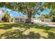 Charming single-story home featuring a beautifully landscaped front yard, a large shade tree, and a covered carport at 4519 S Grady Ave, Tampa, FL 33611