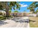 Inviting one-story home showcasing a well-maintained front lawn, carport, and mature trees providing ample shade at 4519 S Grady Ave, Tampa, FL 33611
