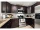 Modern kitchen boasting dark cabinets, granite countertops, and stainless steel appliances for a sleek, contemporary feel at 4519 S Grady Ave, Tampa, FL 33611