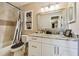 A bathroom with white cabinets, marble countertop, framed mirror, and shower with black and white curtains at 503 Tangerine Dr, Oldsmar, FL 34677