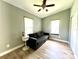This bedroom is staged with a gray futon, wood-look floors and white trim at 503 Tangerine Dr, Oldsmar, FL 34677