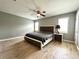 Modern bedroom with neutral paint, wood-look flooring, and a stylish platform bed and fan at 503 Tangerine Dr, Oldsmar, FL 34677