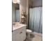 Well-lit bathroom offers a vanity with sink, decorative shelves, and patterned shower curtain at 5406 Rushmere Ct, Palmetto, FL 34221