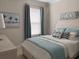 Cozy bedroom features a comfortable bed, soft blue accents, and natural light from the window at 5406 Rushmere Ct, Palmetto, FL 34221