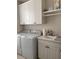 Bright laundry room boasts white cabinetry, washer, and dryer for convenient chores at 5406 Rushmere Ct, Palmetto, FL 34221