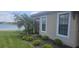 Side view of the house featuring lush landscaping, patio access, and stunning water view at 5406 Rushmere Ct, Palmetto, FL 34221
