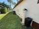 View of the backyard with manicured lawn and essential utilities at 5554 Riva Ridge Dr, Wesley Chapel, FL 33544