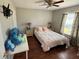 Bright bedroom with wood floors, ceiling fan, plush bedding, and plenty of natural light at 5554 Riva Ridge Dr, Wesley Chapel, FL 33544