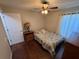 Simple bedroom featuring a full bed, dark wood floors, and natural light at 5554 Riva Ridge Dr, Wesley Chapel, FL 33544