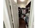 Walk-in closet with dark wood shelving and ample storage space at 5554 Riva Ridge Dr, Wesley Chapel, FL 33544