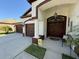 Inviting front entrance with double doors, a covered porch, and a manicured lawn at 5554 Riva Ridge Dr, Wesley Chapel, FL 33544