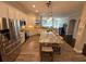 Bright, open kitchen boasts white cabinetry, stainless steel appliances, and a granite island with barstool seating at 5554 Riva Ridge Dr, Wesley Chapel, FL 33544