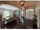 Spacious living area with elegant lighting, an adjacent dining space, and hardwood floors at 5554 Riva Ridge Dr, Wesley Chapel, FL 33544