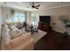 Bright living room featuring a comfortable sectional, coffee table, and entertainment center at 5554 Riva Ridge Dr, Wesley Chapel, FL 33544