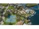 Aerial view of community featuring tennis courts, waterfront homes, private docks, and lush landscaping at 5712 Biscayne Ct # 205, New Port Richey, FL 34652