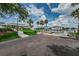 Community boat ramp leading into the water with a sidewalk, grassy area, and tropical palm trees at 5712 Biscayne Ct # 205, New Port Richey, FL 34652
