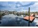 Picturesque view of the community dock with calm waters reflecting the cloudy sky and surrounding waterfront buildings at 5712 Biscayne Ct # 205, New Port Richey, FL 34652