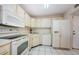 Bright kitchen with white appliances and tile flooring at 5712 Biscayne Ct # 205, New Port Richey, FL 34652
