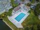 Aerial view of a refreshing community pool with lounge chairs, tables, and a charming adjacent building at 5712 Biscayne Ct # 205, New Port Richey, FL 34652