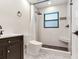 Modern bathroom featuring a marble tiled shower with a rainfall shower head and a sleek black vanity at 6310 95Th E St, Bradenton, FL 34202