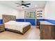 Cozy bedroom featuring blue accent paint, wood-look flooring, ceiling fan, and a large window at 6310 95Th E St, Bradenton, FL 34202
