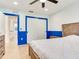 Bright bedroom featuring blue trim, wood-look flooring, ceiling fan, and closet with sliding doors at 6310 95Th E St, Bradenton, FL 34202