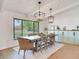 Dining area showcases modern pendant lighting fixtures above a wooden table, adjacent to large windows at 6310 95Th E St, Bradenton, FL 34202