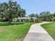 Inviting single-story home showcasing a long driveway leading up to the entrance, framed by lush greenery at 6310 95Th E St, Bradenton, FL 34202