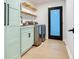 Laundry room with modern appliances, cabinet storage, and floating shelves at 6310 95Th E St, Bradenton, FL 34202