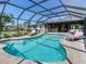 Beautiful pool with a screened enclosure surrounded by lush greenery and a brick paver deck at 6310 95Th E St, Bradenton, FL 34202
