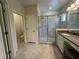 Bright, modern bathroom featuring double sinks, granite countertops, and glass enclosed shower at 6617 Citrus Creek Ln, Tampa, FL 33625