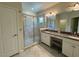 Modern bathroom featuring double sinks, granite countertops, and glass enclosed shower at 6617 Citrus Creek Ln, Tampa, FL 33625