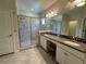 Bright bathroom featuring double sinks, granite countertops, and glass enclosed shower at 6617 Citrus Creek Ln, Tampa, FL 33625