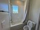 Well-lit bathroom featuring a bathtub, shower, and a window with neighborhood views at 6617 Citrus Creek Ln, Tampa, FL 33625