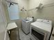 Well-lit laundry room with modern washer and dryer, plus shelving and storage space at 6617 Citrus Creek Ln, Tampa, FL 33625