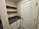 Pantry features granite countertops, white cabinets, and floating wood shelves for storage at 6617 Citrus Creek Ln, Tampa, FL 33625