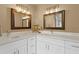 Bright bathroom showcases a double vanity with mirrors, sconce lighting, white cabinets, and elegant countertops at 6712 Jennifer Dr, Temple Terrace, FL 33617