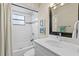 Stylish bathroom features a modern vanity, a shower with white subway tile, and a decorative mirror at 6712 Jennifer Dr, Temple Terrace, FL 33617