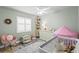 Charming bedroom features soft green walls, a crib, white dresser, rocking chair, and plenty of toys at 6712 Jennifer Dr, Temple Terrace, FL 33617