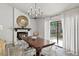 Inviting dining area featuring a brick fireplace, elegant lighting, and backyard views at 6712 Jennifer Dr, Temple Terrace, FL 33617