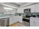 Well-equipped kitchen with white cabinets, stainless steel appliances, and modern backsplash at 6712 Jennifer Dr, Temple Terrace, FL 33617